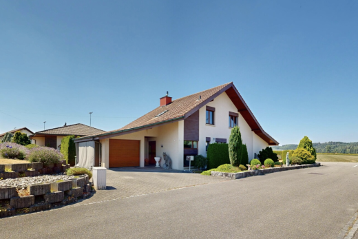 view of home with stucco siding, a chimney, driveway, and a garage