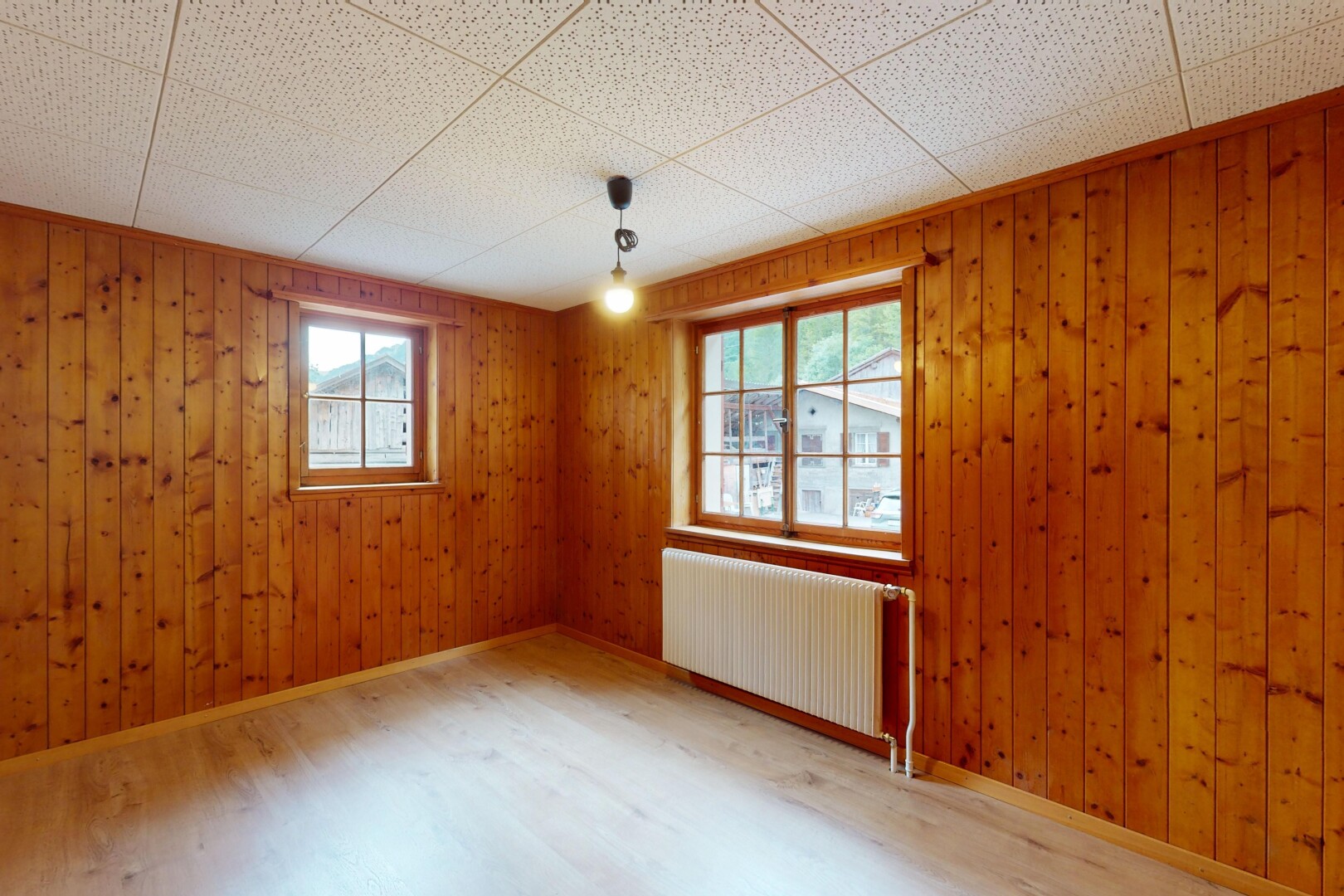 pièce vide avec radiateur, wood finish floor, sol en finition bois, natural light, et lumière naturelle