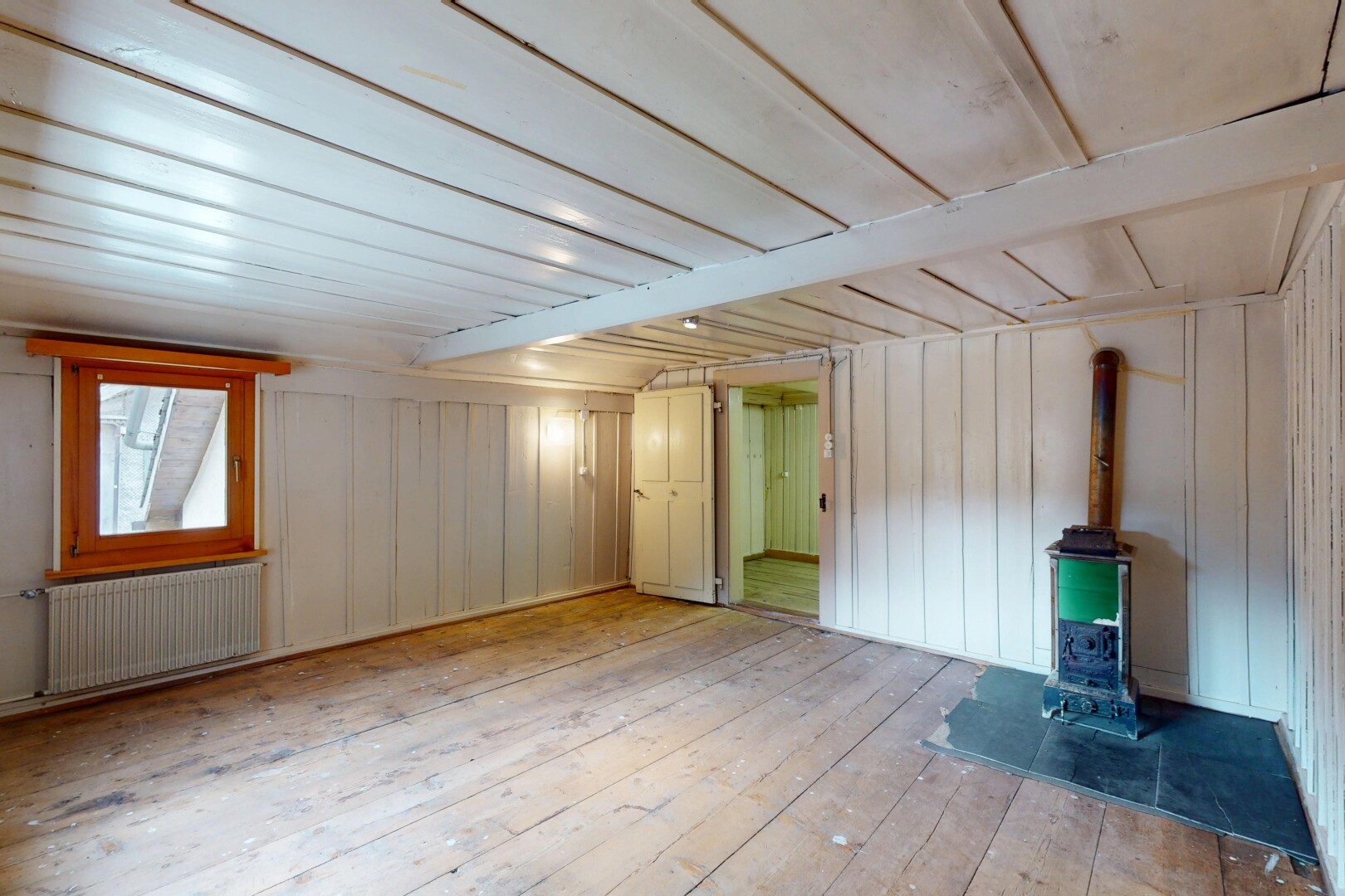 pièce vide avec poêle à bois, radiateur, wood finish floor, sol en finition bois, et inside property