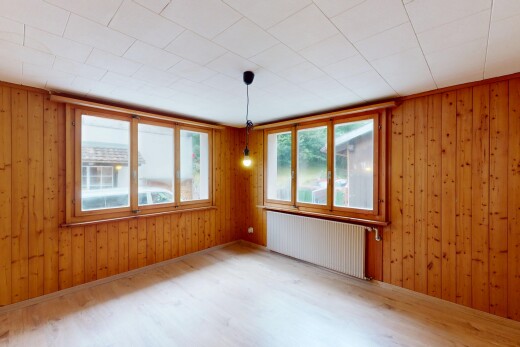 unfurnished room featuring radiator heating unit, wood walls, and wood finished floors