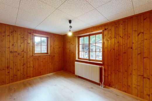 empty room with radiator heating unit, wood finished floors, and wood walls