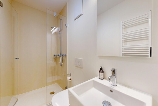 salle de bains avec radiateur, salle de bain complète, évier, toilette, et douche