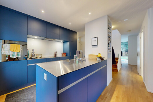 cuisine avec armoires à panneau plat, armoires bleues, sol en finition bois, wood finish floor, et inside property