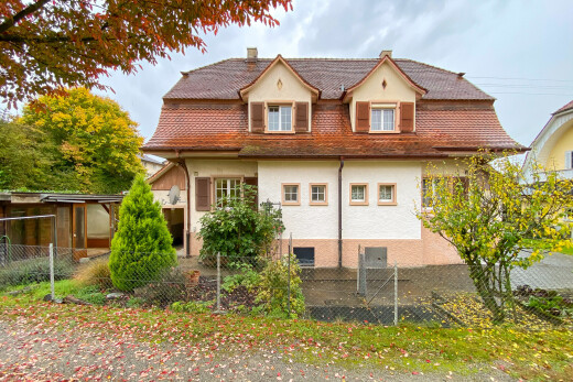 außenansicht mit stuckverkleidung, zaun, property visible, schornstein, und overcast