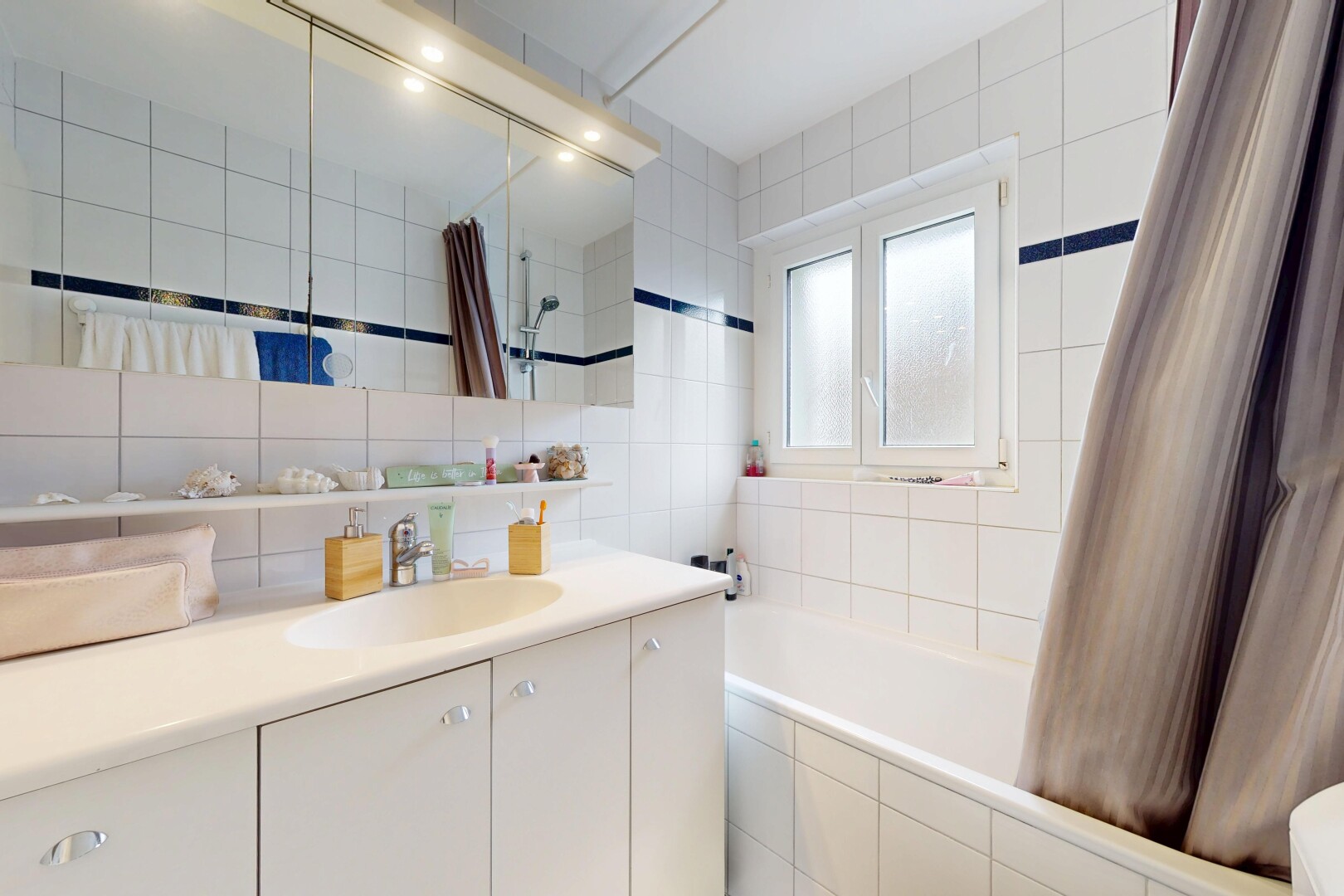 salle de bains avec mur en carrelage, tile wall, salle de bain complète, lavabo (ou coiffeuse selon le contexte), et inside property