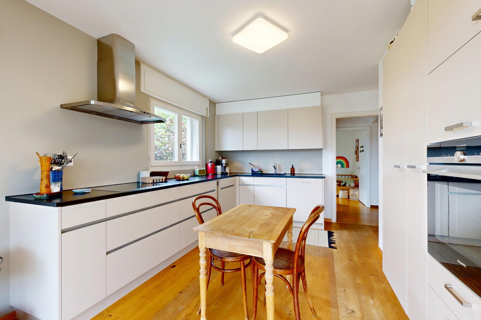 cuisine avec hotte, natural light, lumière naturelle, dark countertops, et plans de travail