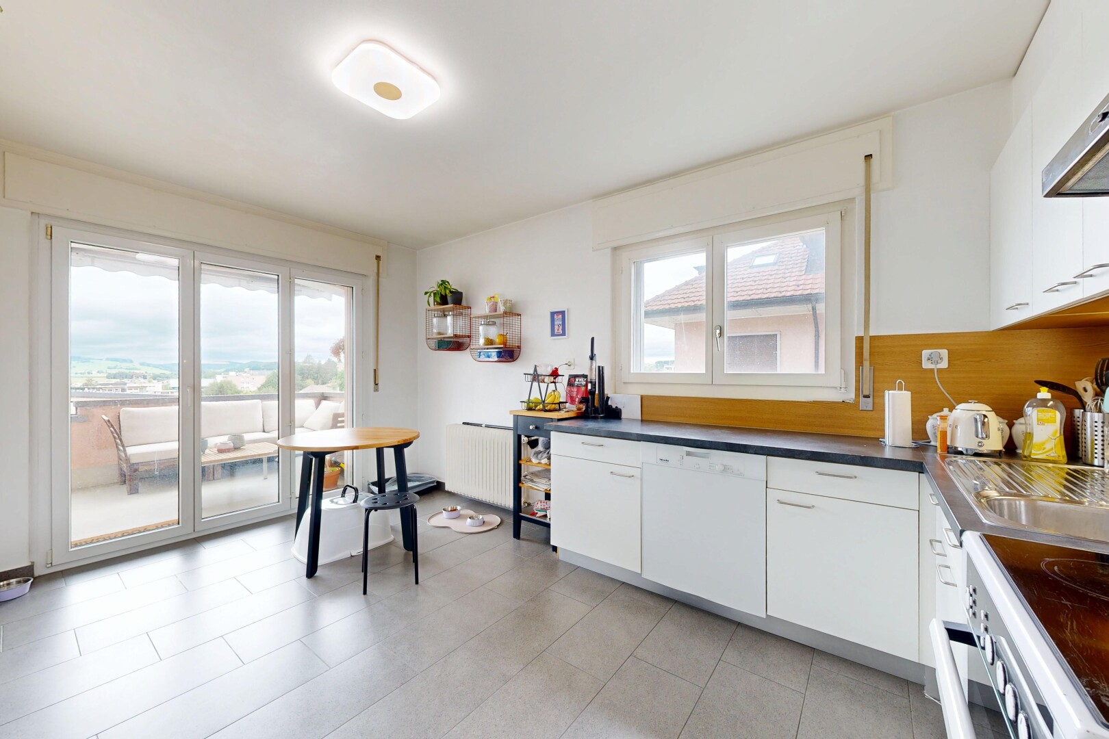 cuisine avec light floor, white cabinets, armoires blanches, cuisinière, et radiateur