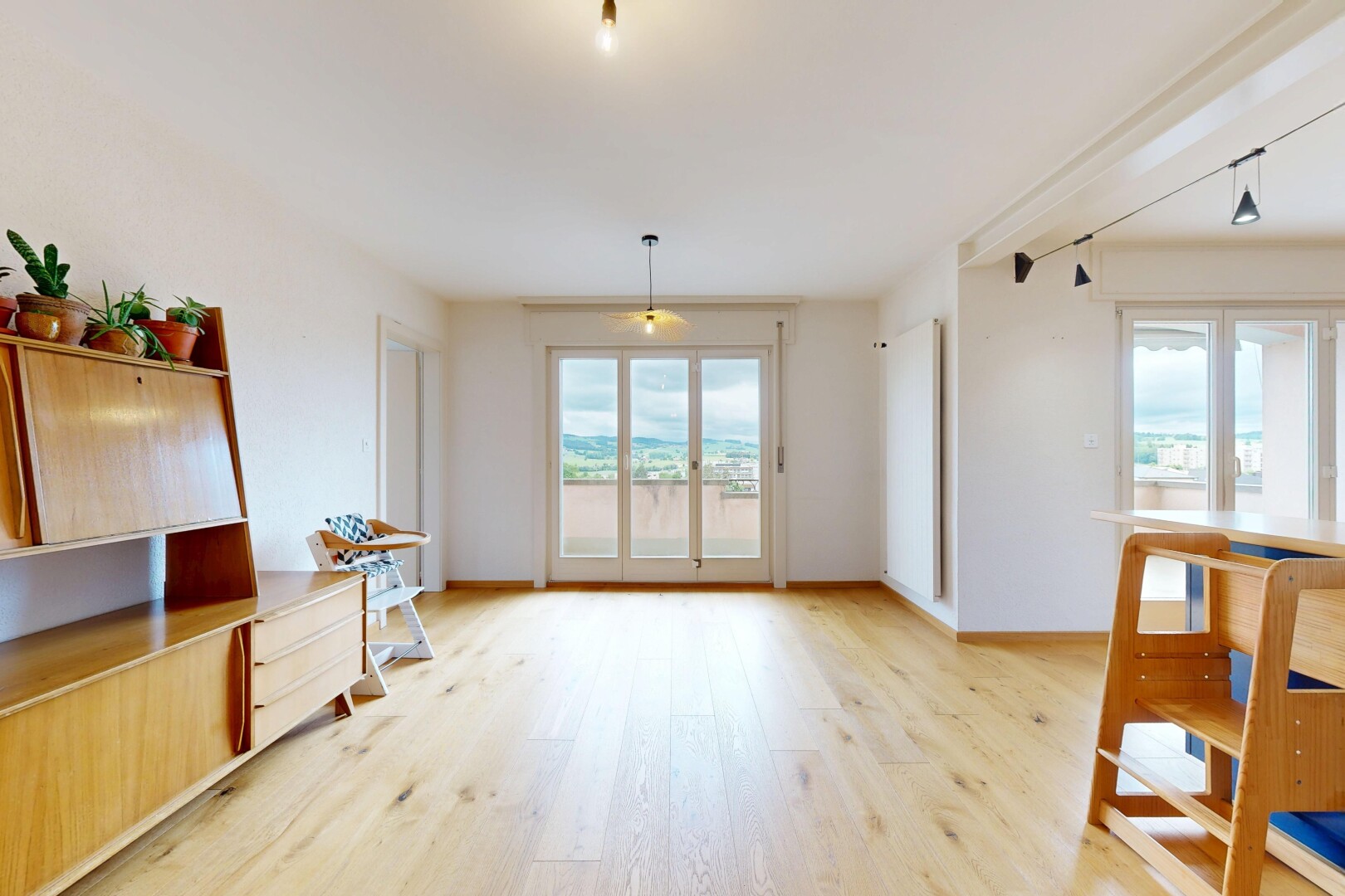 salon avec sol en finition bois, wood finish floor, cloison sèche, drywall, et light floor