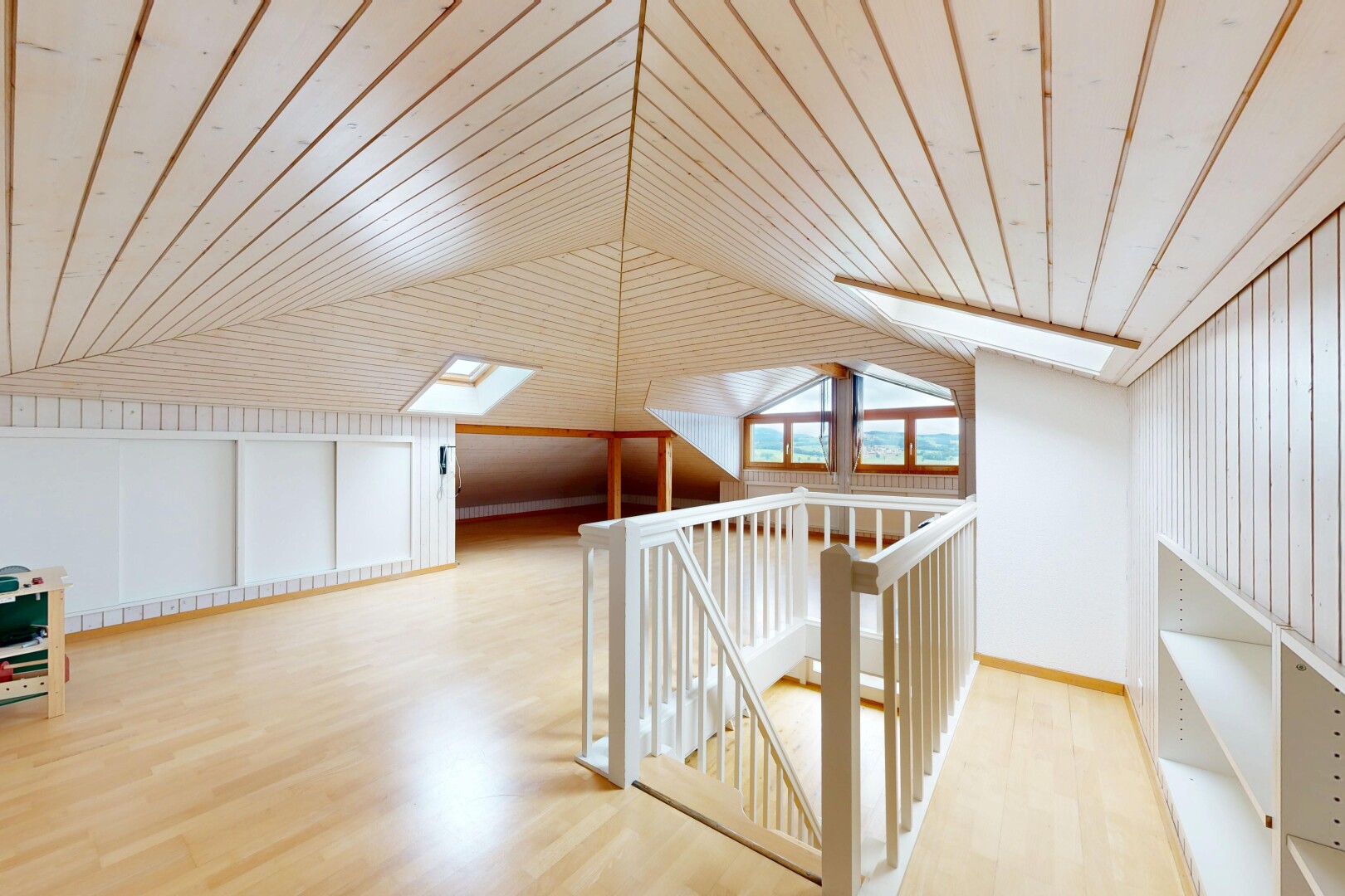 couloir avec inside property, wood finish floor, sol en finition bois, puits de lumière, et vaulted ceiling