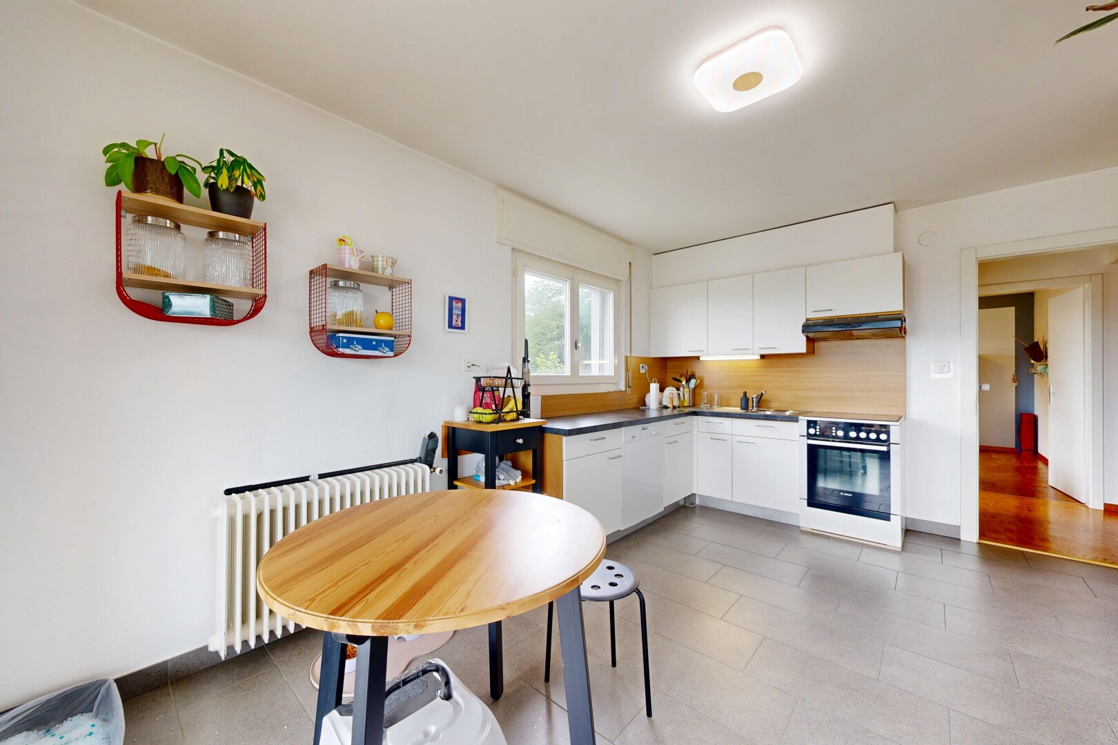cuisine avec radiateur, drywall, cloison sèche, natural light, et lumière naturelle