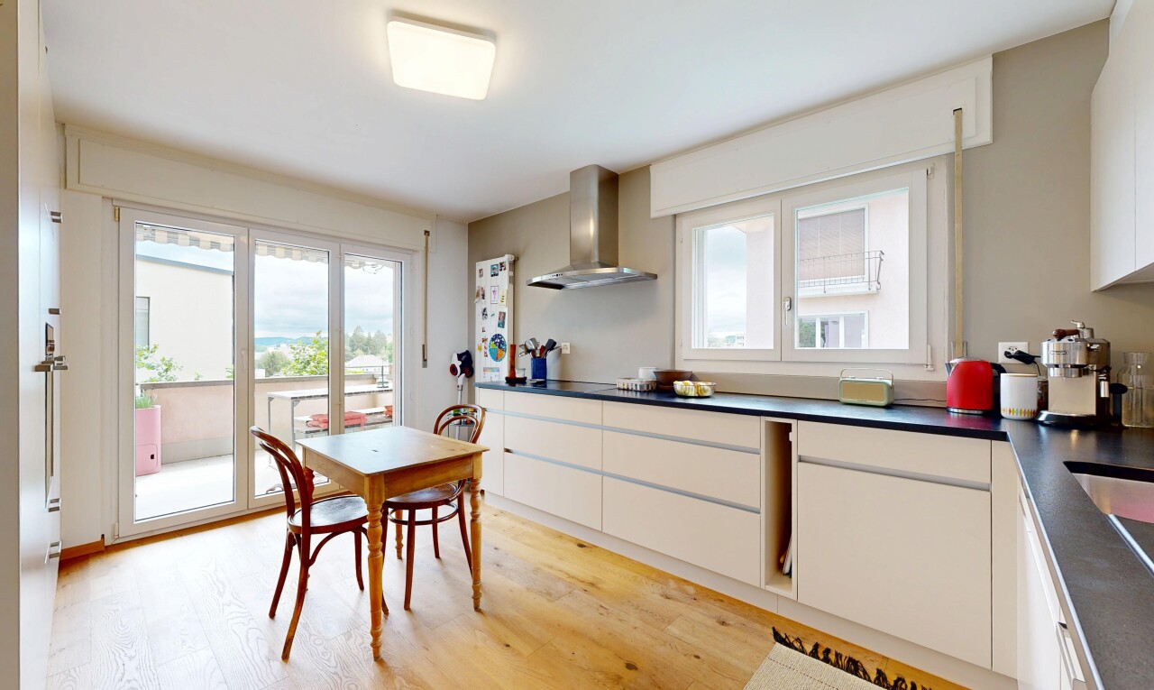 cuisine avec dark countertops, plans de travail, white cabinets, armoires blanches, et wood finish floor