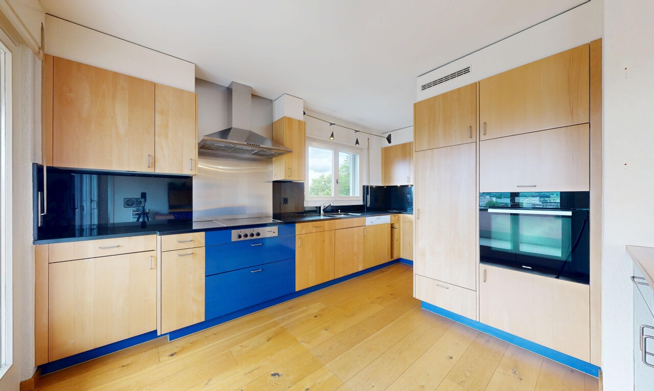 cuisine avec light brown cabinets, armoires marron clair, light floor, four, et hotte
