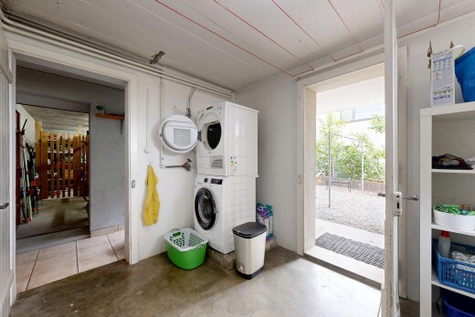 buanderie avec lave-linge et sèche-linge superposés, sol en béton, concrete floor, inside property, et light floor