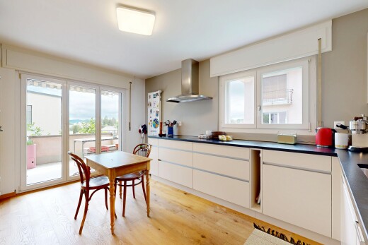 cuisine avec dark countertops, plans de travail, white cabinets, armoires blanches, et wood finish floor