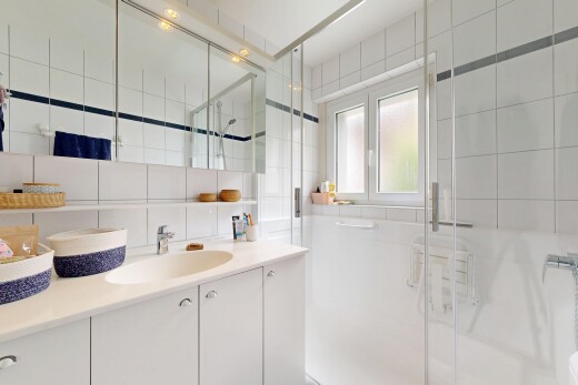 salle de bains avec mur en carrelage, tile wall, douche, lavabo (ou coiffeuse selon le contexte), et salle de bain complète