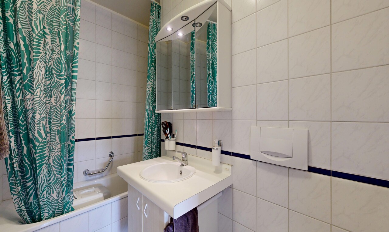 salle de bains avec mur en carrelage, tile wall, miroir, salle de bain complète, et inside property