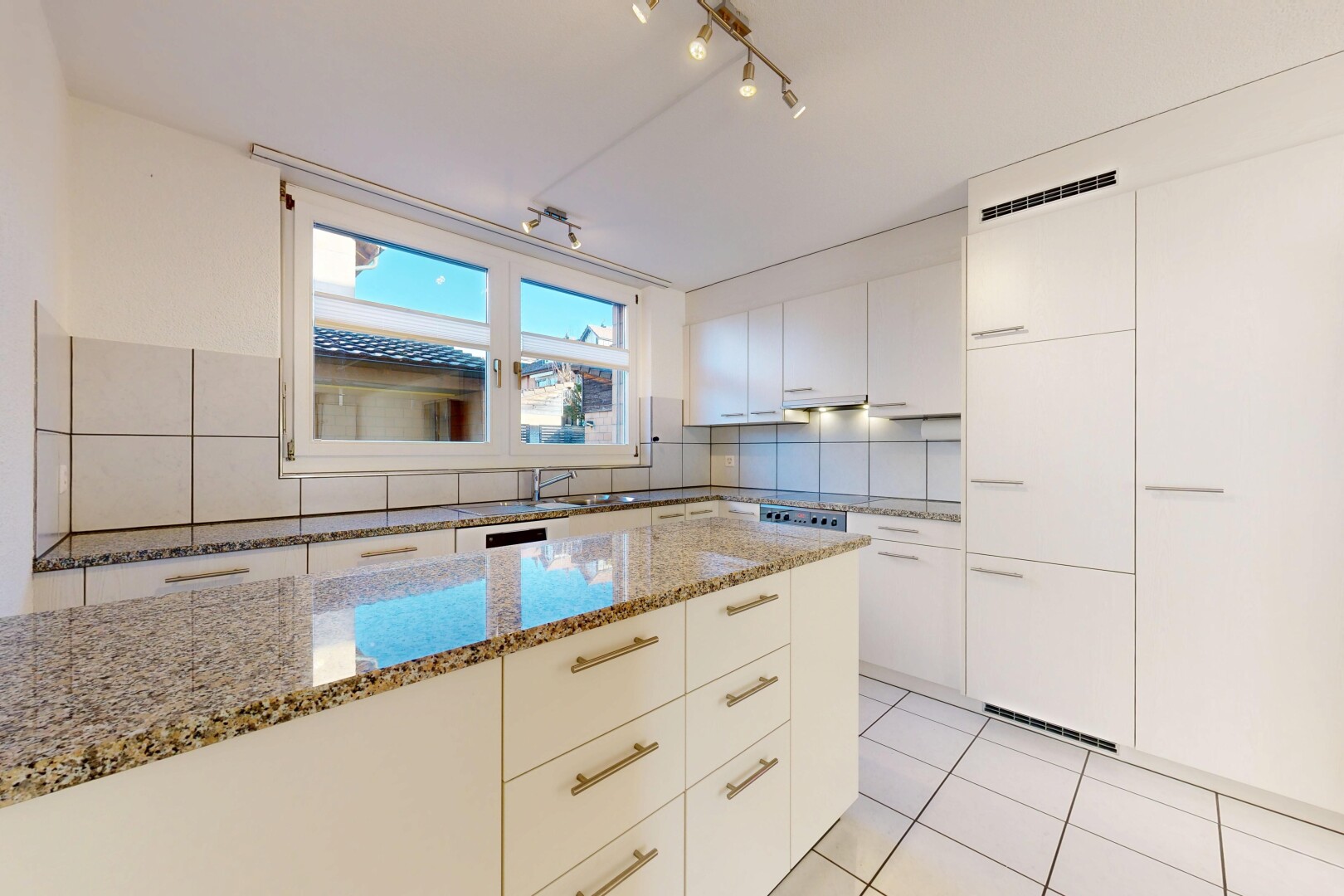 kitchen with modern cabinets, light stone countertops, track lighting, white cabinets, and light tile patterned floors