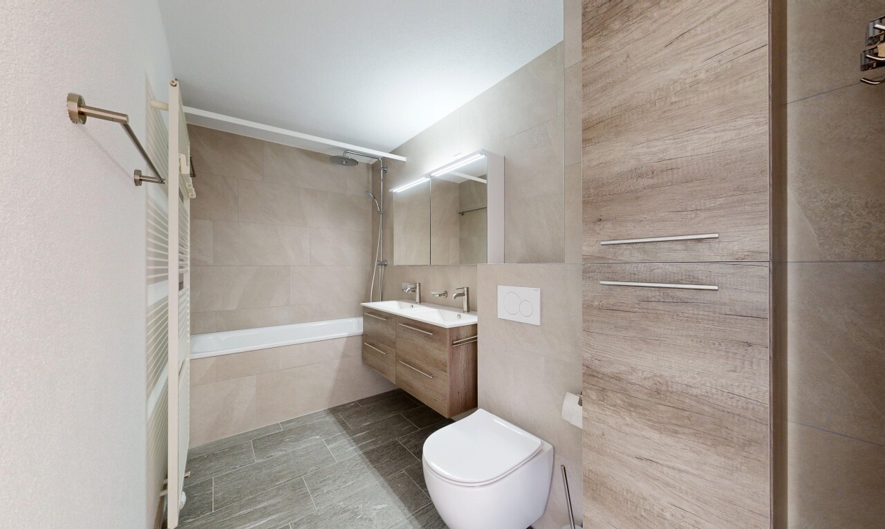 bathroom featuring tiled shower / bath combo, vanity, tile walls, and light tile patterned floors