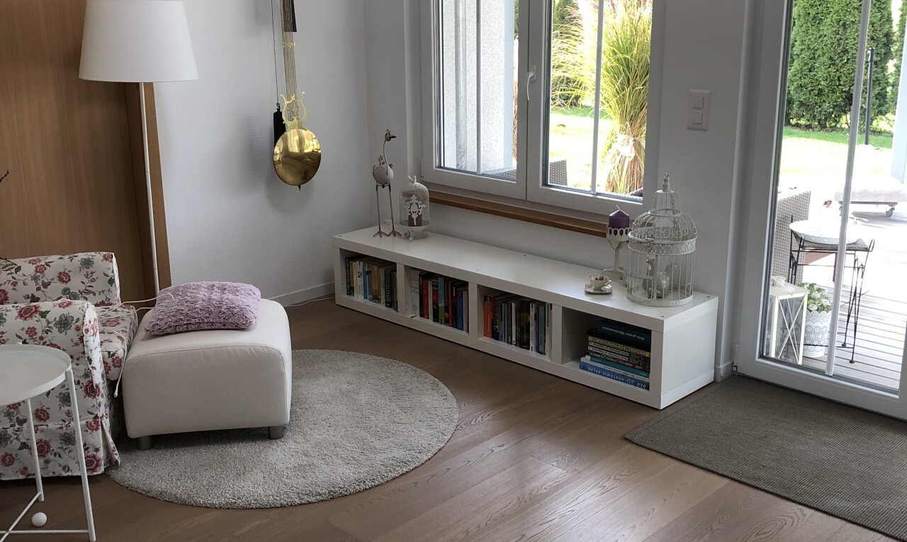 salon avec accès à l'extérieur, cloison sèche, drywall, sol en finition bois, et wood finish floor