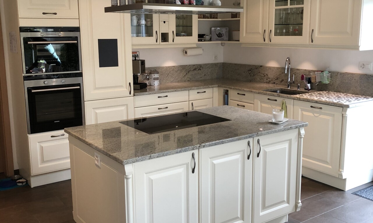 cuisine avec glass insert cabinets, armoires avec insert en verre, stone countertops, plans de travail en pierre, et raised cabinets