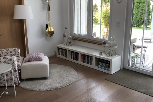 salon avec accès à l'extérieur, cloison sèche, drywall, sol en finition bois, et wood finish floor