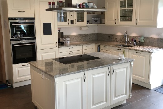 cuisine avec glass insert cabinets, armoires avec insert en verre, stone countertops, plans de travail en pierre, et raised cabinets