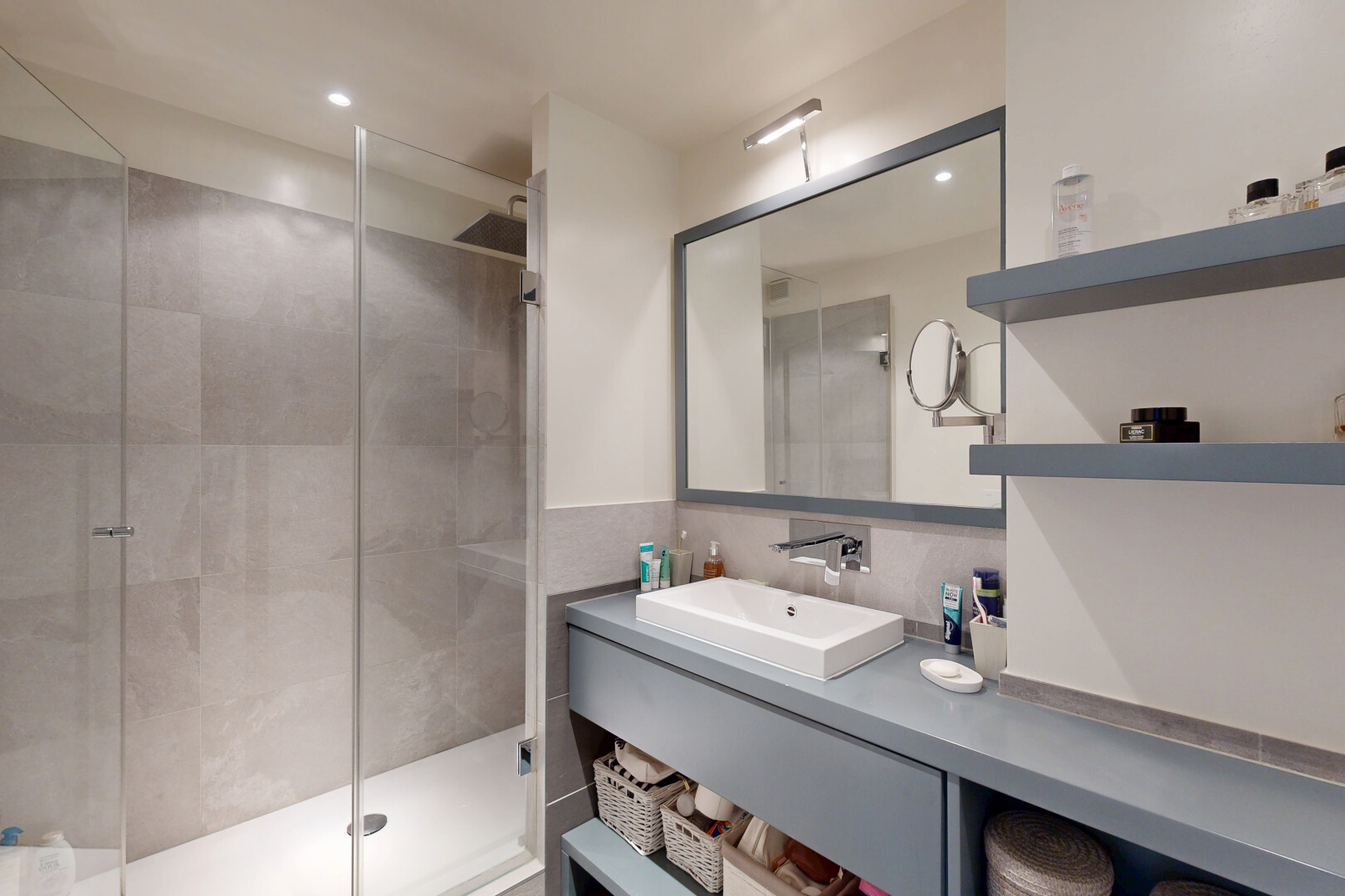 salle de bains avec douche, salle de bain complète, évier, lavabo (ou coiffeuse selon le contexte), et éclairage encastré