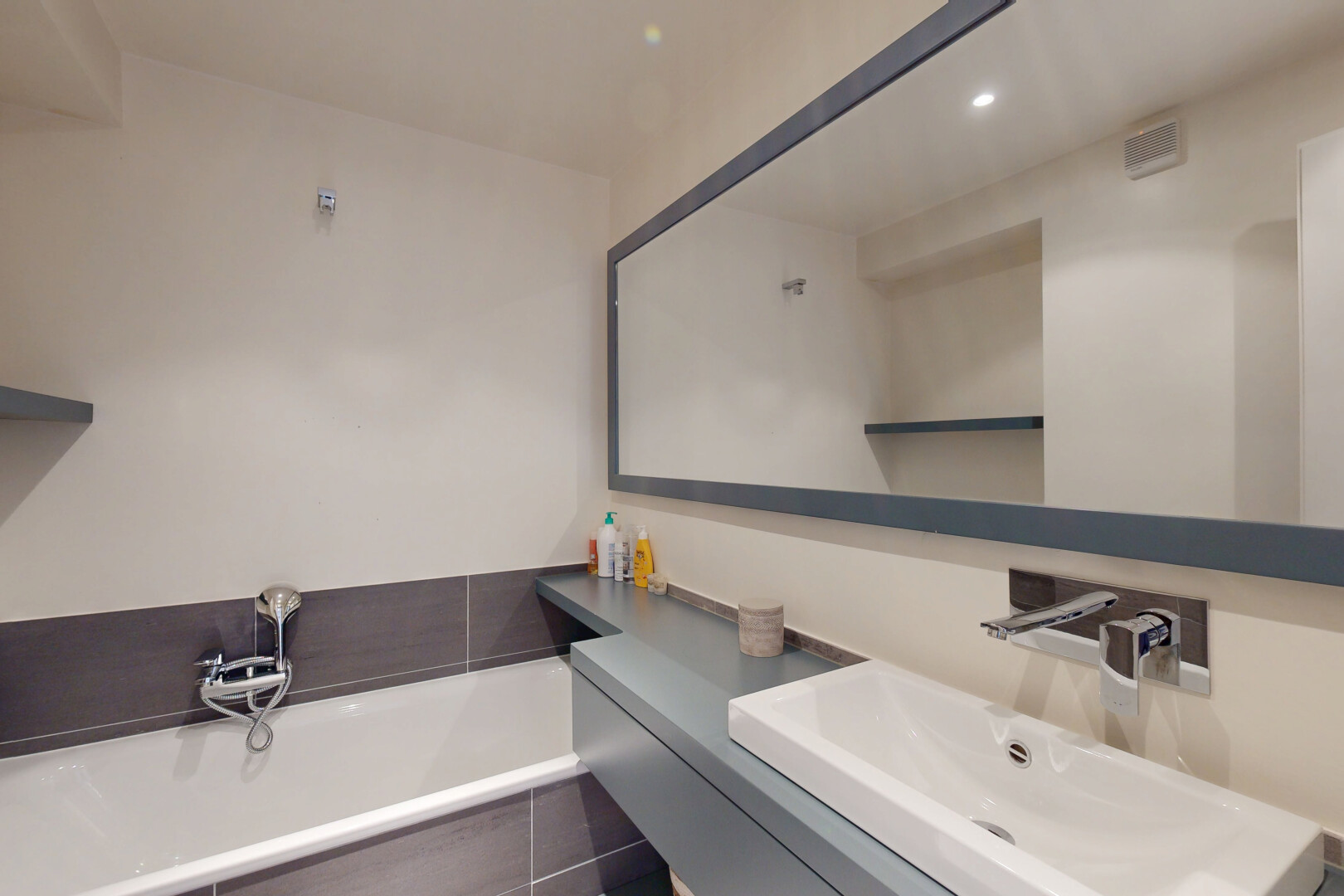 salle de bains avec bain, évier, lavabo (ou coiffeuse selon le contexte), salle de bain complète, et drywall