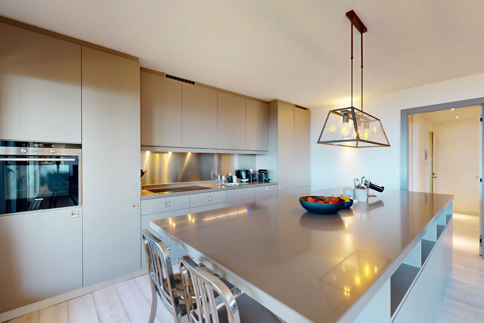 cuisine avec flat panel cabinets, armoires à panneau plat, light floor, four, et kitchen island