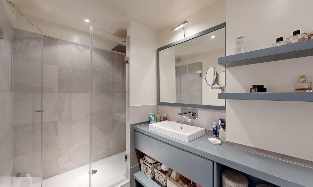 salle de bains avec douche, salle de bain complète, évier, lavabo (ou coiffeuse selon le contexte), et éclairage encastré