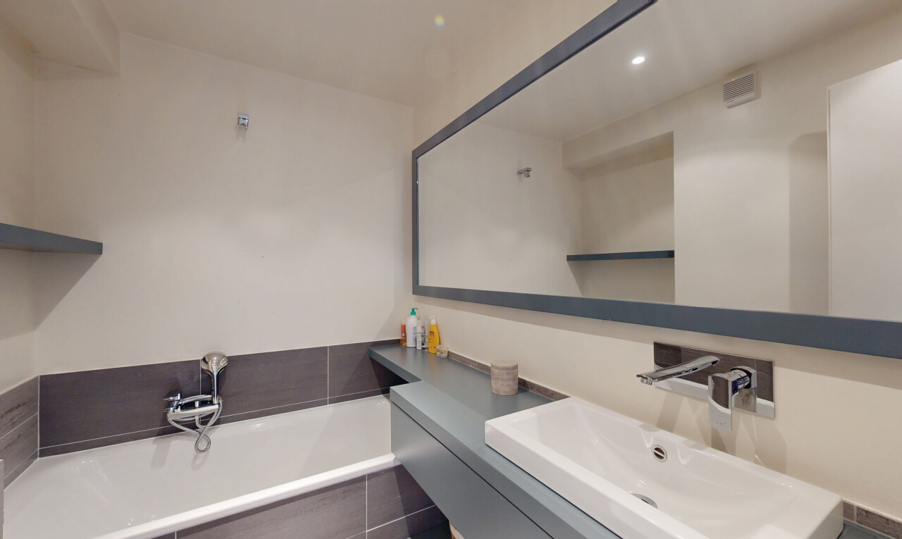 salle de bains avec bain, évier, lavabo (ou coiffeuse selon le contexte), salle de bain complète, et drywall