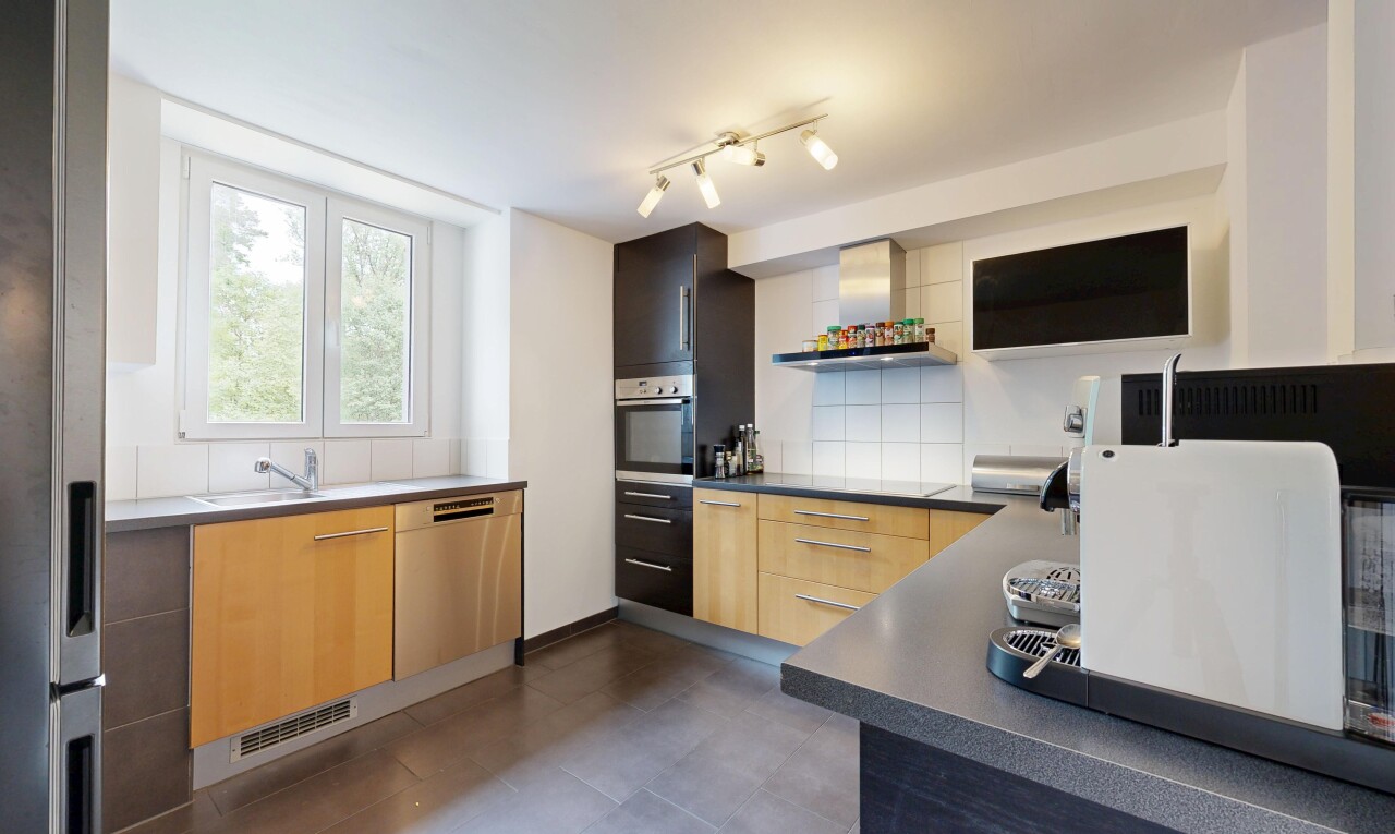cuisine avec dark floor, hotte, plans de travail, dark countertops, et four