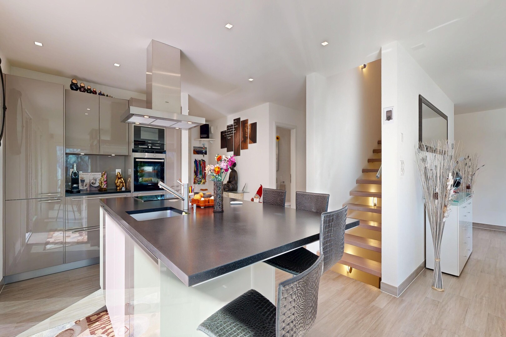 cuisine avec wood finish floor, sol en finition bois, hotte, light floor, et armoires à panneau plat