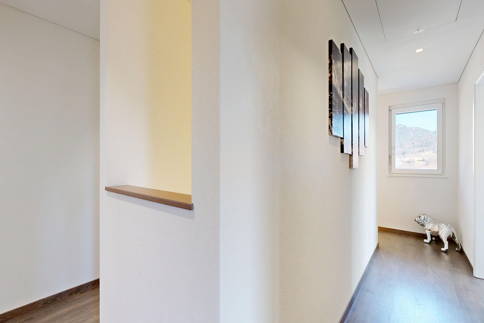 couloir avec inside property, escaliers escamotables, wood finish floor, sol en finition bois, et natural light