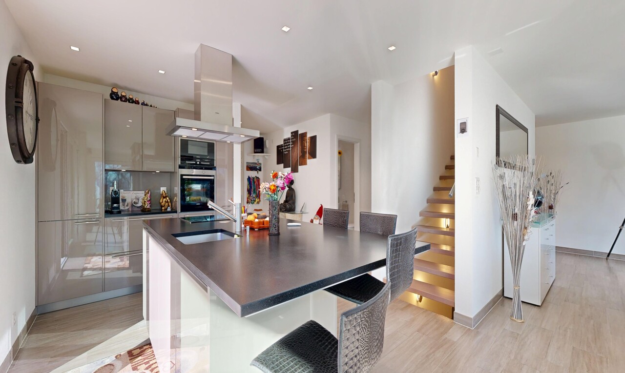 cuisine avec wood finish floor, sol en finition bois, hotte, light floor, et armoires à panneau plat