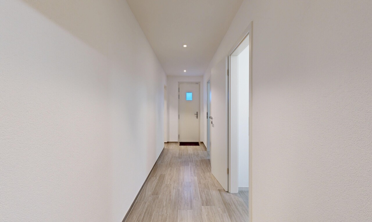 couloir avec wood finish floor, sol en finition bois, light floor, inside property, et recessed lighting