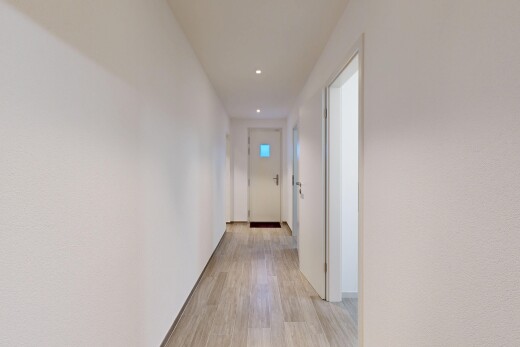 couloir avec wood finish floor, sol en finition bois, light floor, inside property, et recessed lighting