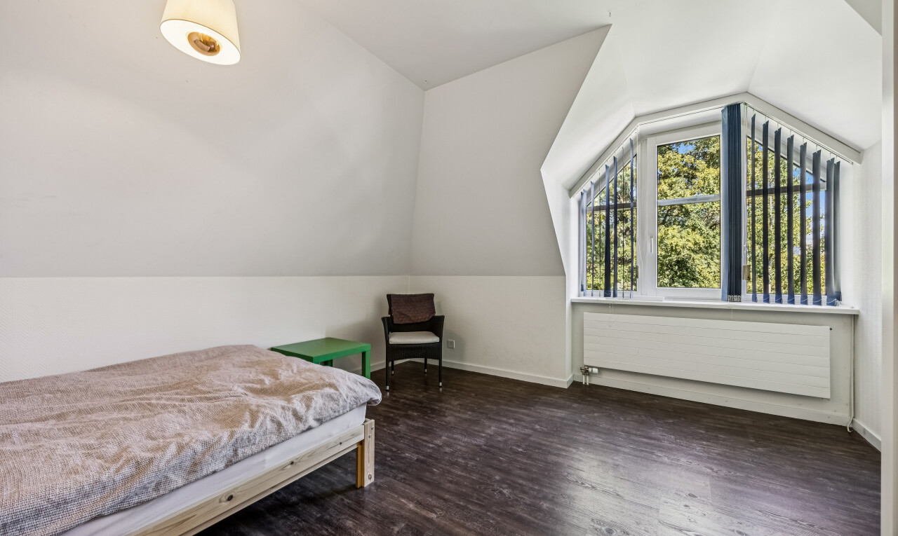 room / bedroom with lofted ceiling, dark wood-style floors, and radiator