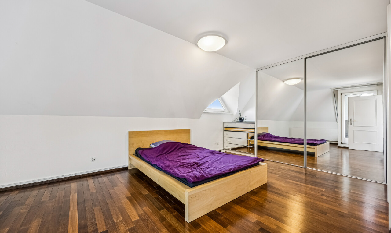 zimmer / schlafzimmer mit drywall, gipskartonwand, wood finish floor, holzfußboden, und kleiderschrank