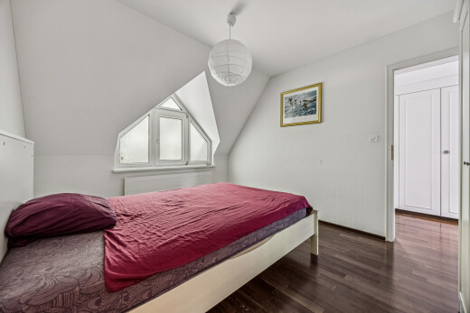zimmer / schlafzimmer mit dark floor, wood finish floor, holzfußboden, vaulted ceiling, und dachschräge