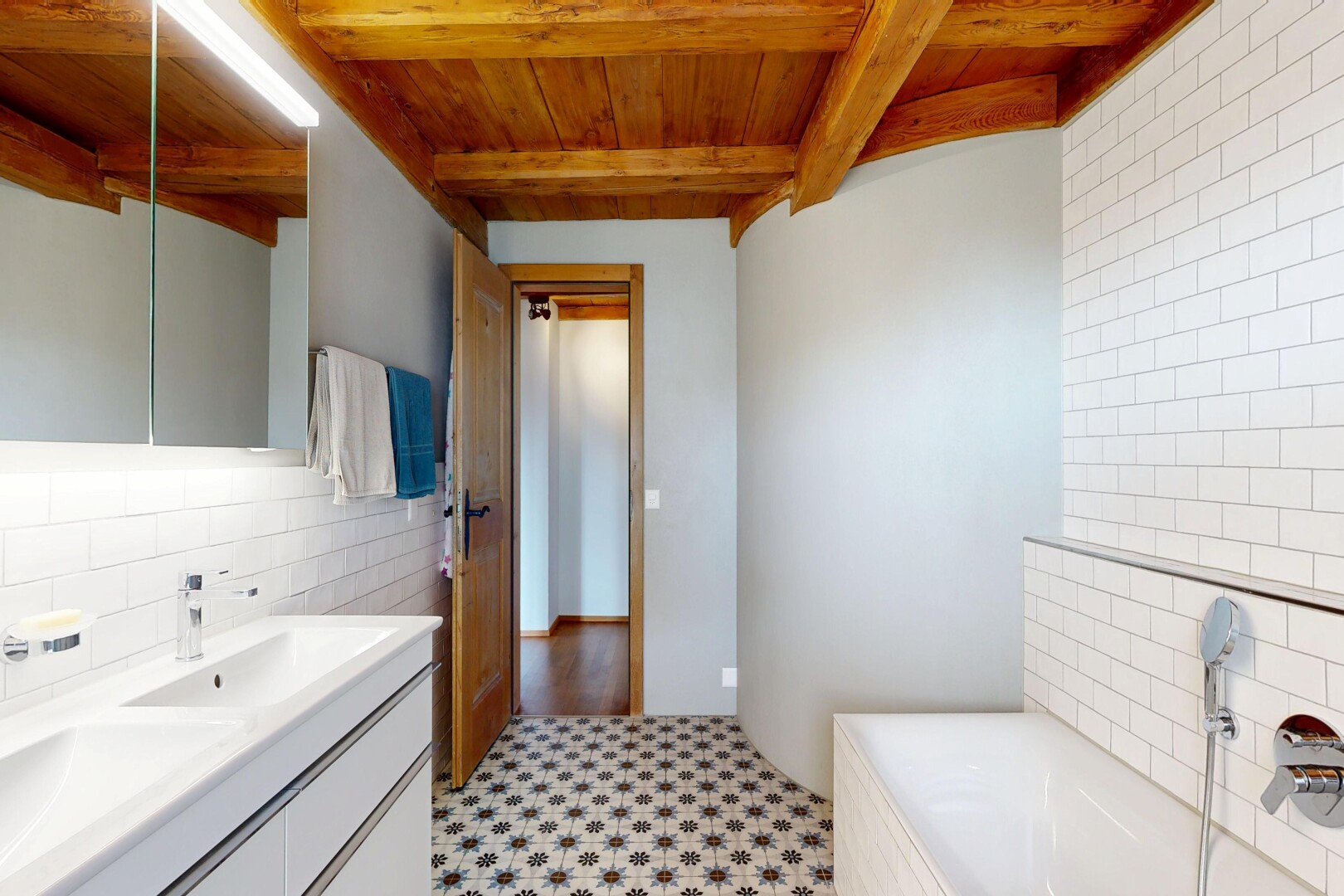salle de bains avec light floor, miroir, wood ceiling, plafond en bois, et double vasque