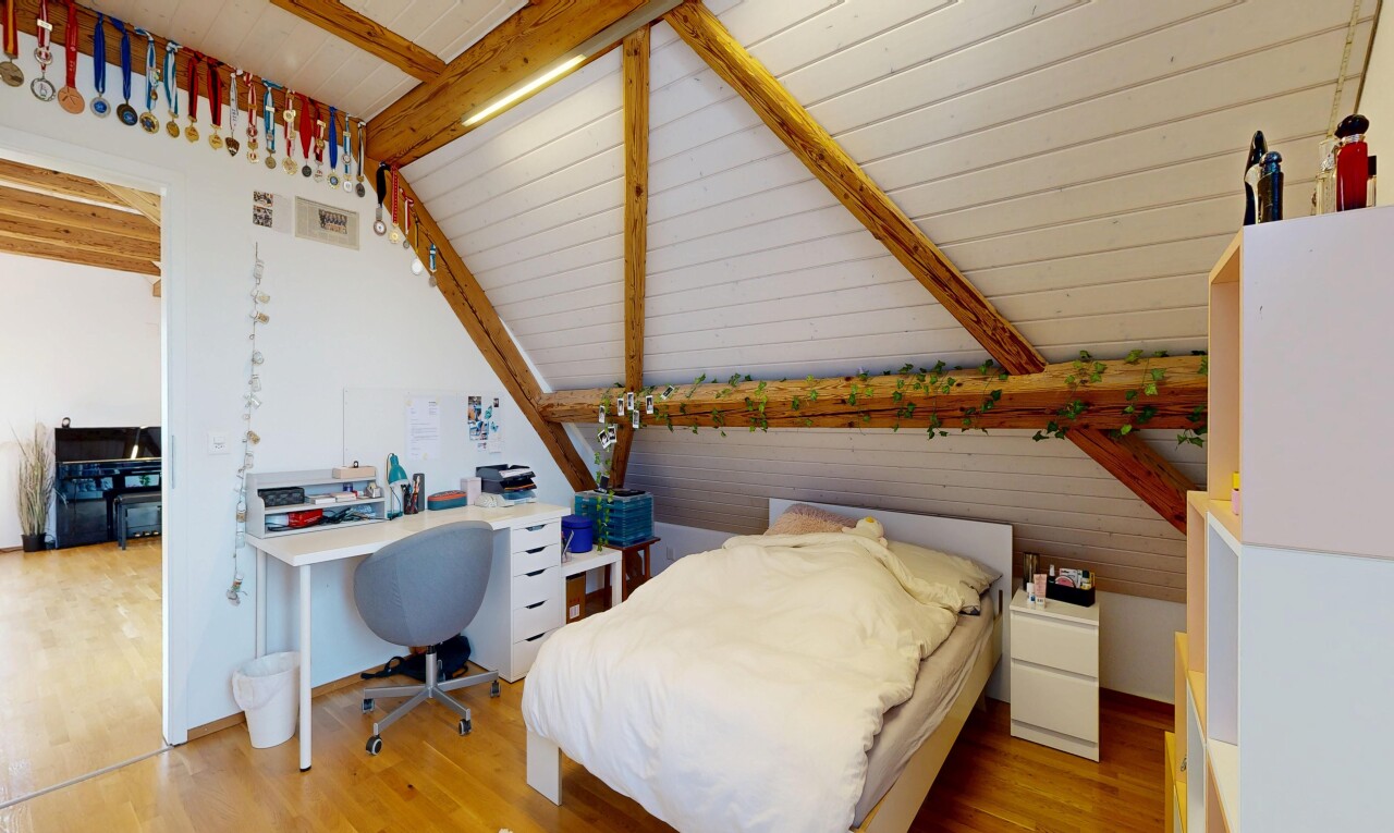 chambre avec inside property, vaulted ceiling, plafond voûté, espace bureau, et wood finish floor