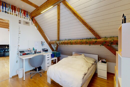chambre avec inside property, vaulted ceiling, plafond voûté, espace bureau, et wood finish floor