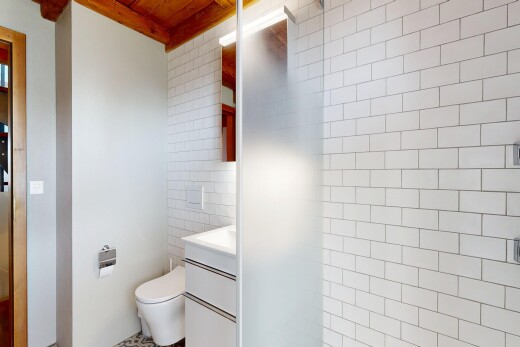 salle de bains avec lavabo (ou coiffeuse selon le contexte), toilette, salle de bain complète, inside property, et mur en carrelage