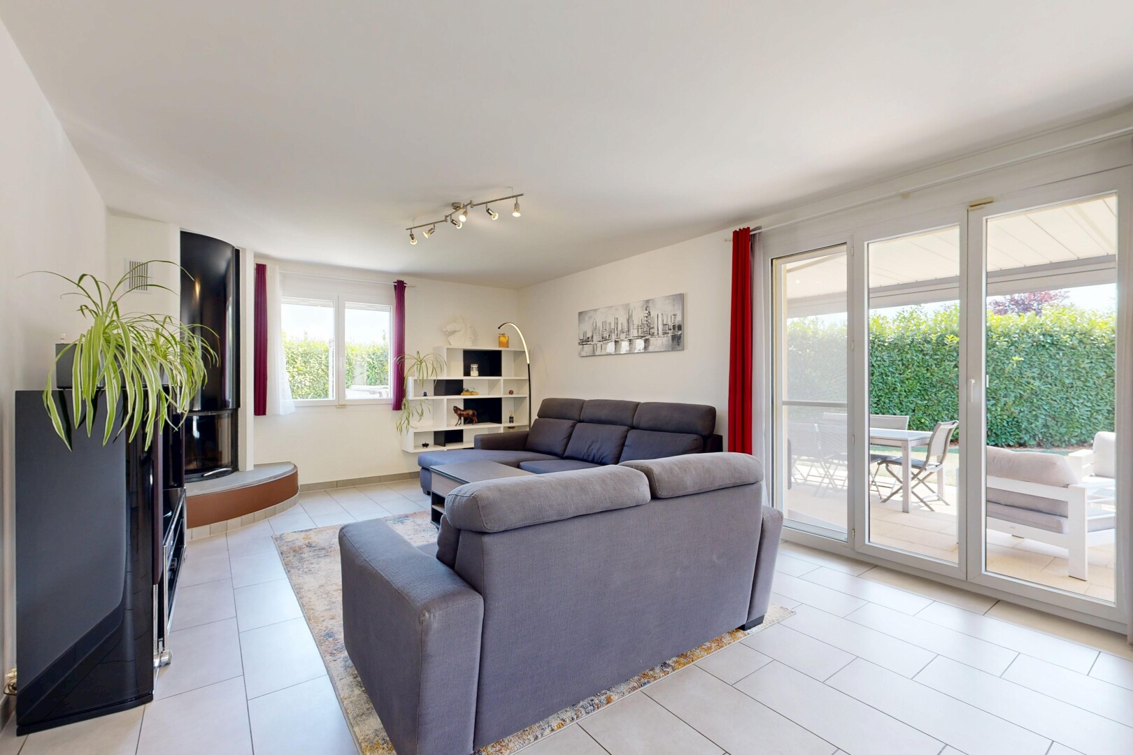 salon avec éclairage sur rail, drywall, cloison sèche, inside property, et light floor