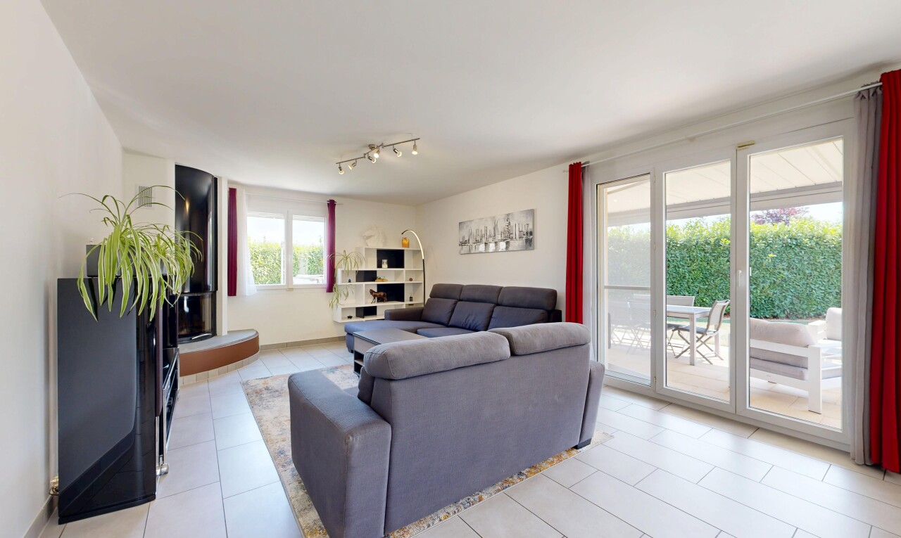 salon avec éclairage sur rail, drywall, cloison sèche, inside property, et light floor