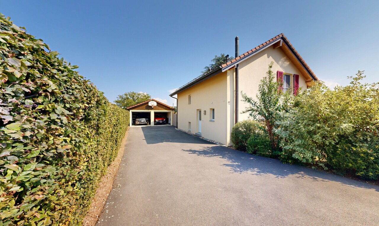 façade avec garage détaché, toit en tuiles, structure extérieure, bardage en stuc, et property visible