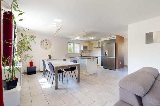 salon / salle à manger avec éclairage sur rail, light floor, full kitchen, drywall, et cloison sèche