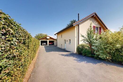 façade avec garage détaché, toit en tuiles, structure extérieure, bardage en stuc, et property visible