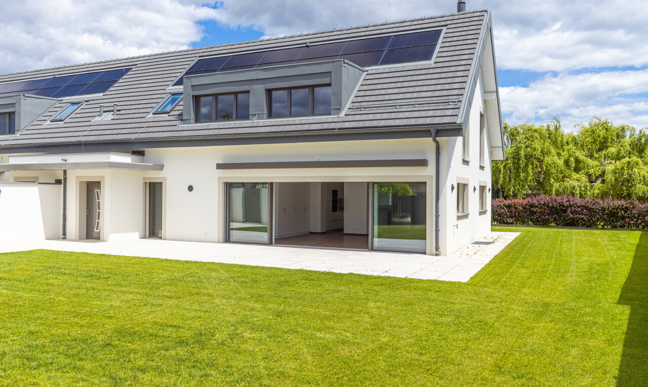 außenansicht mit rasen, solaranlage, property visible, day time, und stuckverkleidung